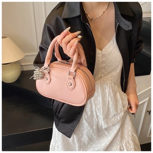 Détail du mini sac rose clair avec texture litchi et accessoire de boule argentée