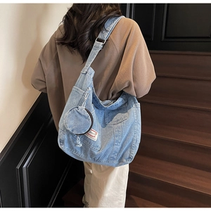 Dettaglio borsa tote in denim azzurro con portamonete rotondo e tracolla regolabile