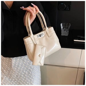 Detail of cream bucket bag with mini envelope pouch and metal twist lock closure