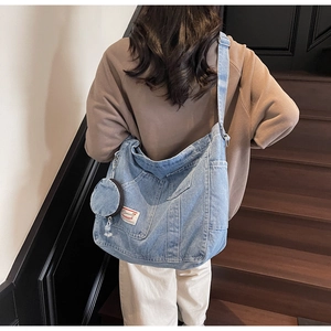 Dettaglio della borsa tote in denim blu con tasche esterne e portamonete rotondo