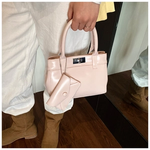 Pink bucket bag with glossy finish featuring a swivel lock and mini envelope charm