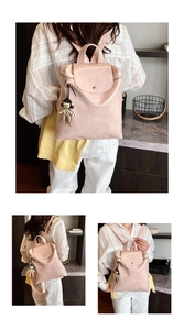 Detail of light pink PU leather backpack with gloss finish and cute black pendant accessory
