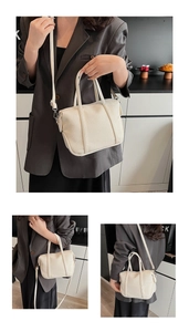 Close-up of beige lychee-textured leather handbag with adjustable strap and metal hardware