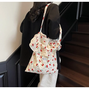 Detail of white canvas tote bag with red cherry print and ruffled edge decoration