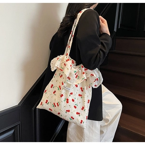 Detail of floral tote bag with ruffled edges and Magic Pocket logo patch on model