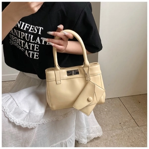 Macro shot of cream bucket bag with metal twist lock and detachable mini coin pouch