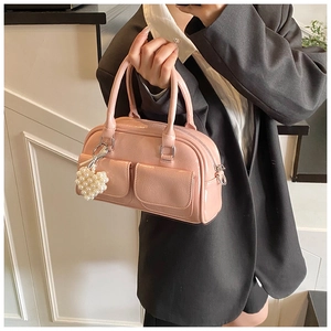 Detail der rosa Lackleder Boston Tasche mit Herzperlen-Anhänger und Vordertaschen