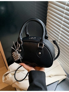 Sac polochon noir en cuir grainé avec pendentif argenté et bandoulière amovible
