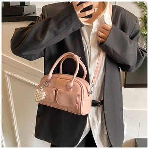 Nahaufnahme der rosa glänzenden Boston Bag aus Lackleder mit Herzanhängern aus Perlen