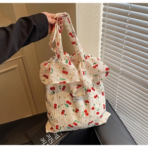 Detail of cherry print bubble gauze bag featuring frill trim and Magic pocket label