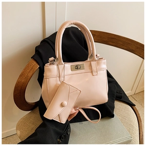 Close-up of pink bucket bag with silver turn-lock and small pouch on a stylish chair