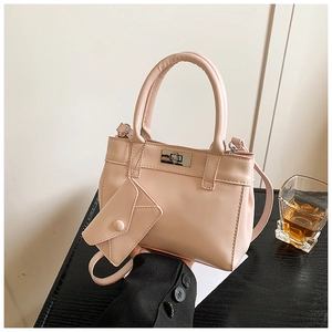 Detail of pink PU leather bucket bag with silver metal turn-lock and envelope charm pendant