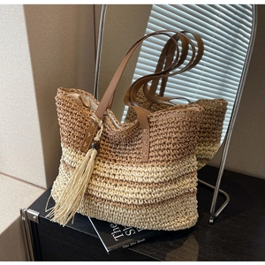 Detail of handwoven tote bag with contrast stitching, leather strap and wooden bead tassels