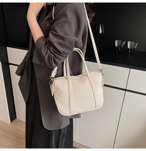 Detailed macro view of cream PU leather handbag with lychee texture and silver hardware