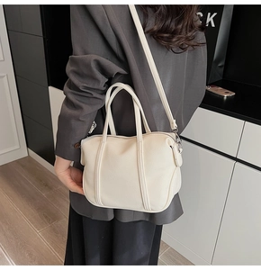Chic off-white lychee grain tote bag worn crossbody by a model in a minimal setting