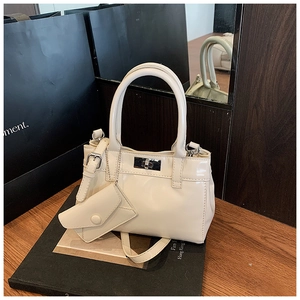Detail of off-white glossy bucket bag with silver twist lock and mini coin purse
