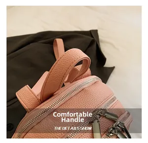 Detail view of pink lychee leather backpack showing comfortable handle and double zippers