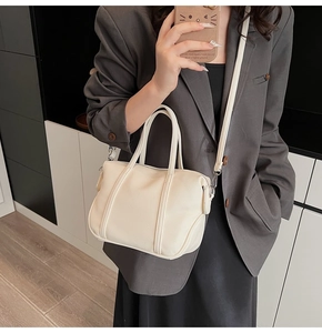 Chic off-white litchi grain handbag shown on model in a modern urban office setting