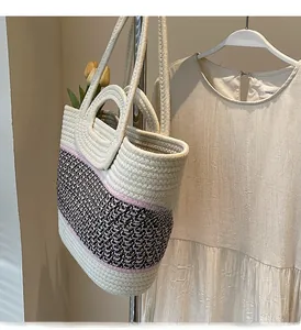 Detail of woven cotton bucket bag with rounded handle and beige lavender cord texture