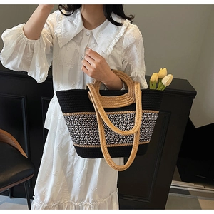 Detail of contrast handmade straw tote with woven patterns and sturdy round ring handles