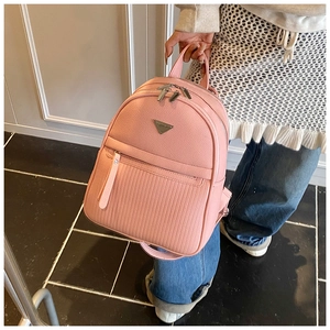 Detail of pink faux leather backpack featuring pebbled texture and quilted patterns