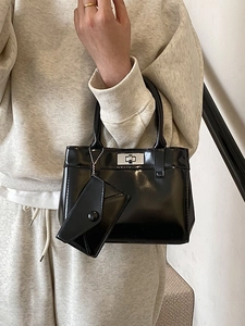 Elegant black patent leather bucket bag with silver twist lock and mini charm accessory