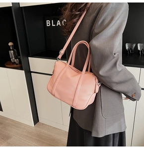 Detail showing dusty rose PU leather Boston bag with lychee texture and side strap carry