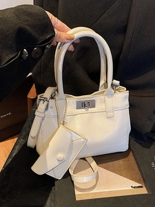 Chic beige patent leather bucket bag with silver twist lock and mini charm pouch