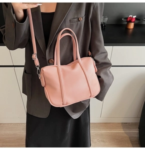 Pink litchi grain leather handbag with adjustable shoulder strap and silver hardware