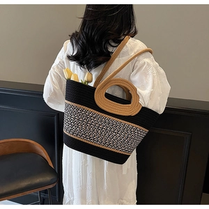 Detailed view of bicolor woven tote bag with round handle and shoulder strap being worn