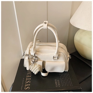 Details der cremefarbenen Boston Bag mit Vintage-Faltenleder und Perlenherz-Anhänger
