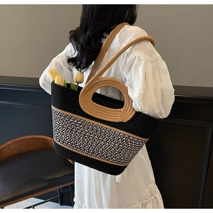 Detail of bicolor woven tote bag with circular handles and a shoulder strap