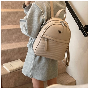 Close-up of beige lychee leather backpack showing vertical stripe embossed details
