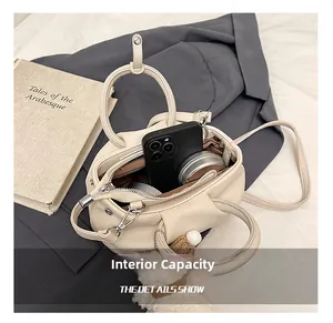 Detail view of cream lychee texture pleated bucket bag interior with silver hardware