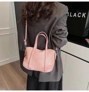 Pink faux leather bag detail showing adjustable shoulder strap on a model in-style