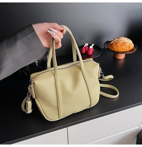 Close-up of light green lychee pattern leather handbag with silver hardware and strap