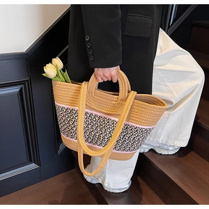 Detail of large woven beach tote showing three-color texture and round ring handles