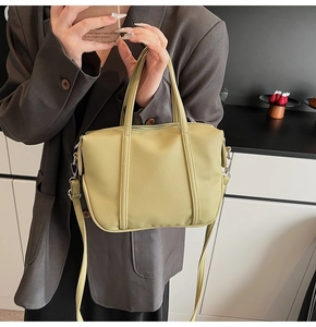 Detail of light yellow lychee pattern leather handbag with silver metal hardware