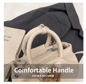 Detail of cream lychee leather handbag with smooth handle and silver metal accents
