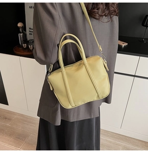 Detailed view of pale green lychee leather texture on a trendy shoulder handbag