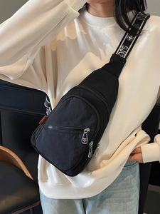 Lightweight black nylon chest bag with multi-layer zippers and textured strap