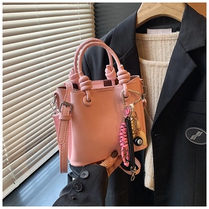 Detailed view of pink bucket bag with knot handle and billiard number 8 charm