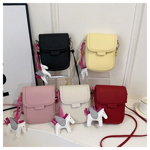 Détail de mini sacs bandoulière en cinq couleurs avec breloques cheval et cuir grainé