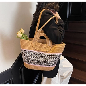 Detail of hand-woven tote bag with decorative tri-color band and dual handle design