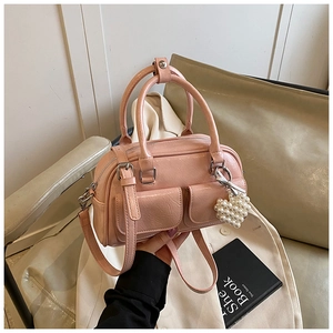 Rosa Boston Tasche mit vorderen Taschen und einem eleganten Perlenherz-Anhänger
