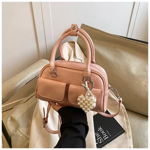 Detail der rosa Boston Bag mit Struktur-Finish, Doppelklappentaschen und Perlenherz-Anhänger