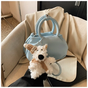 Detailed view of light blue pleated bucket bag with lychee texture and cute dog charm