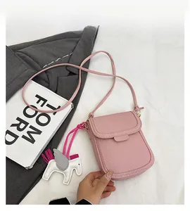 Détail du mini sac téléphone rose en cuir grainé avec un charmant pendentif cheval