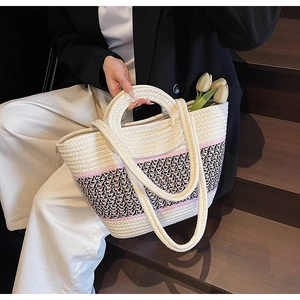 Detail showing dual handles and textured knit pattern on the beige woven beach tote