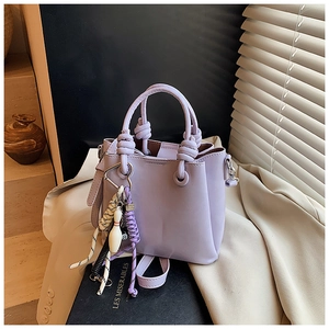 Close-up of lilac bucket bag with knotted handle and unique bowling ball charm detail